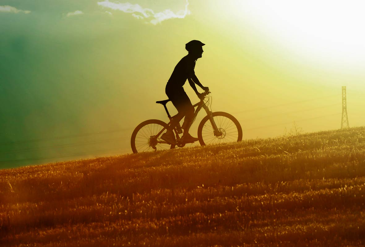 Man on bike with helmet biking uphill