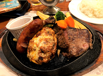 An example of a Westernized Japanese food (Yoshoku). On this platter, it includes Hambagu (hamburger steak), sausage, rice and vegetables.